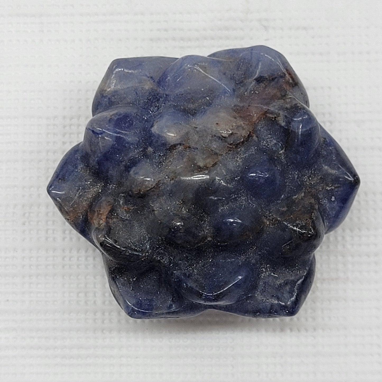 Sodalite polished lotus flower-shaped carving on a white background