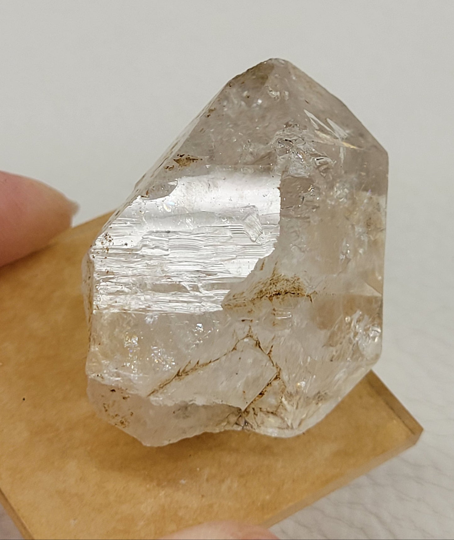 Crystal quartz specimens, with inclusions, on a stand, against a white background.
