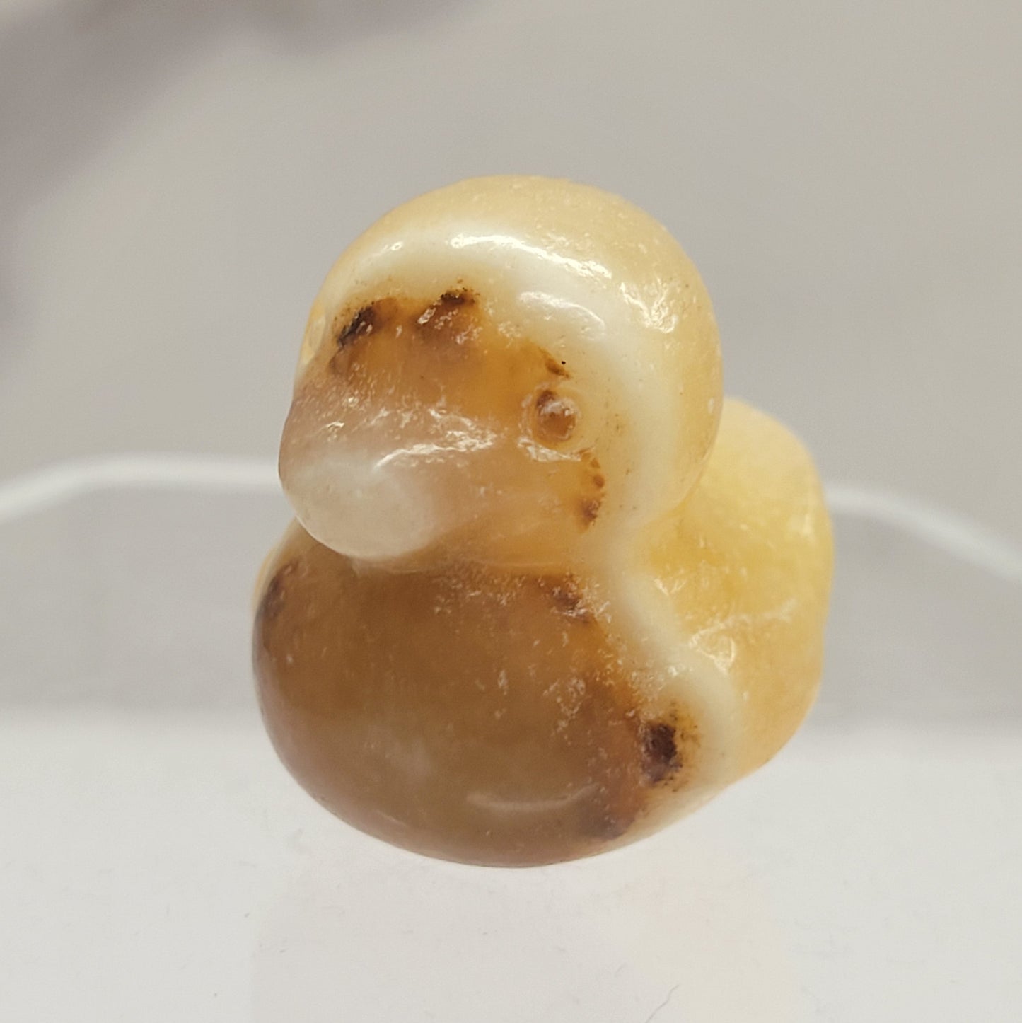 Orange Calcite carving of a duck on a white background