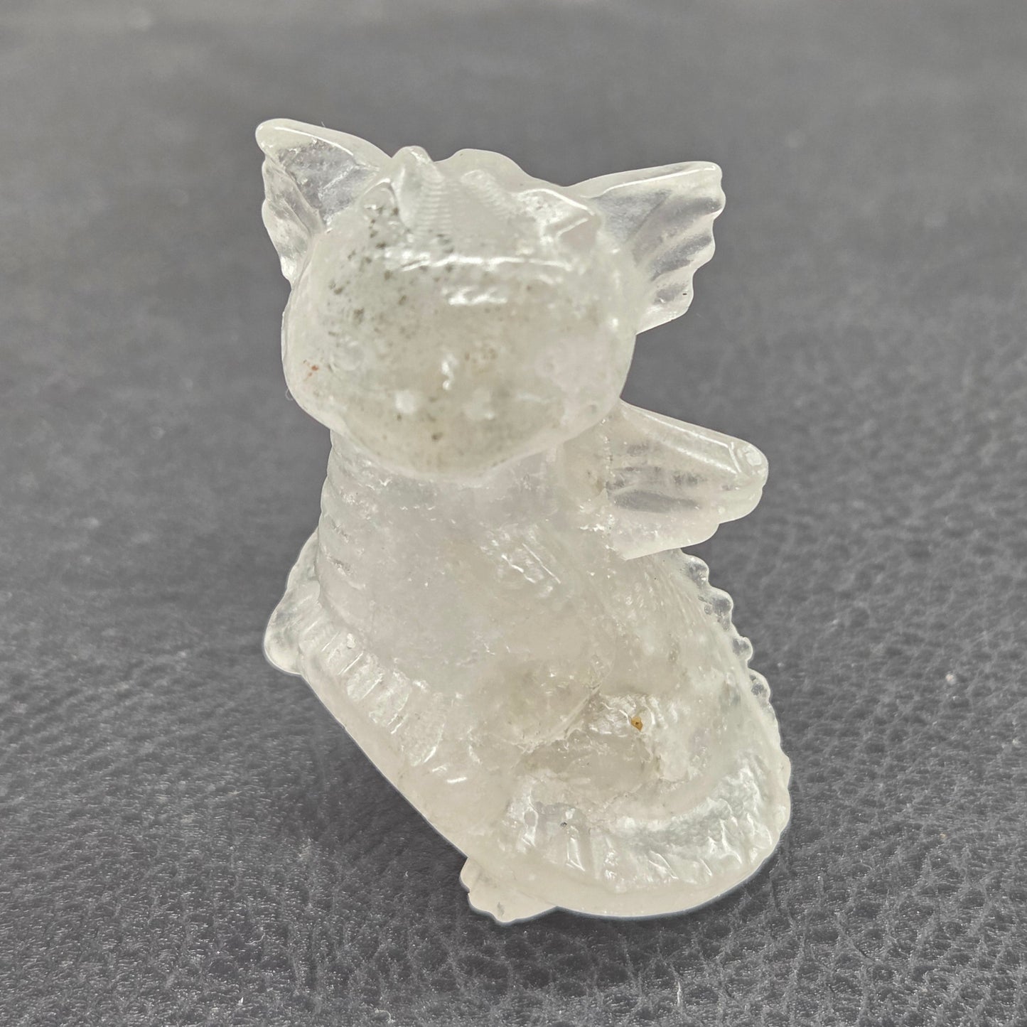 Clear crystal dragon figurine on a gray background