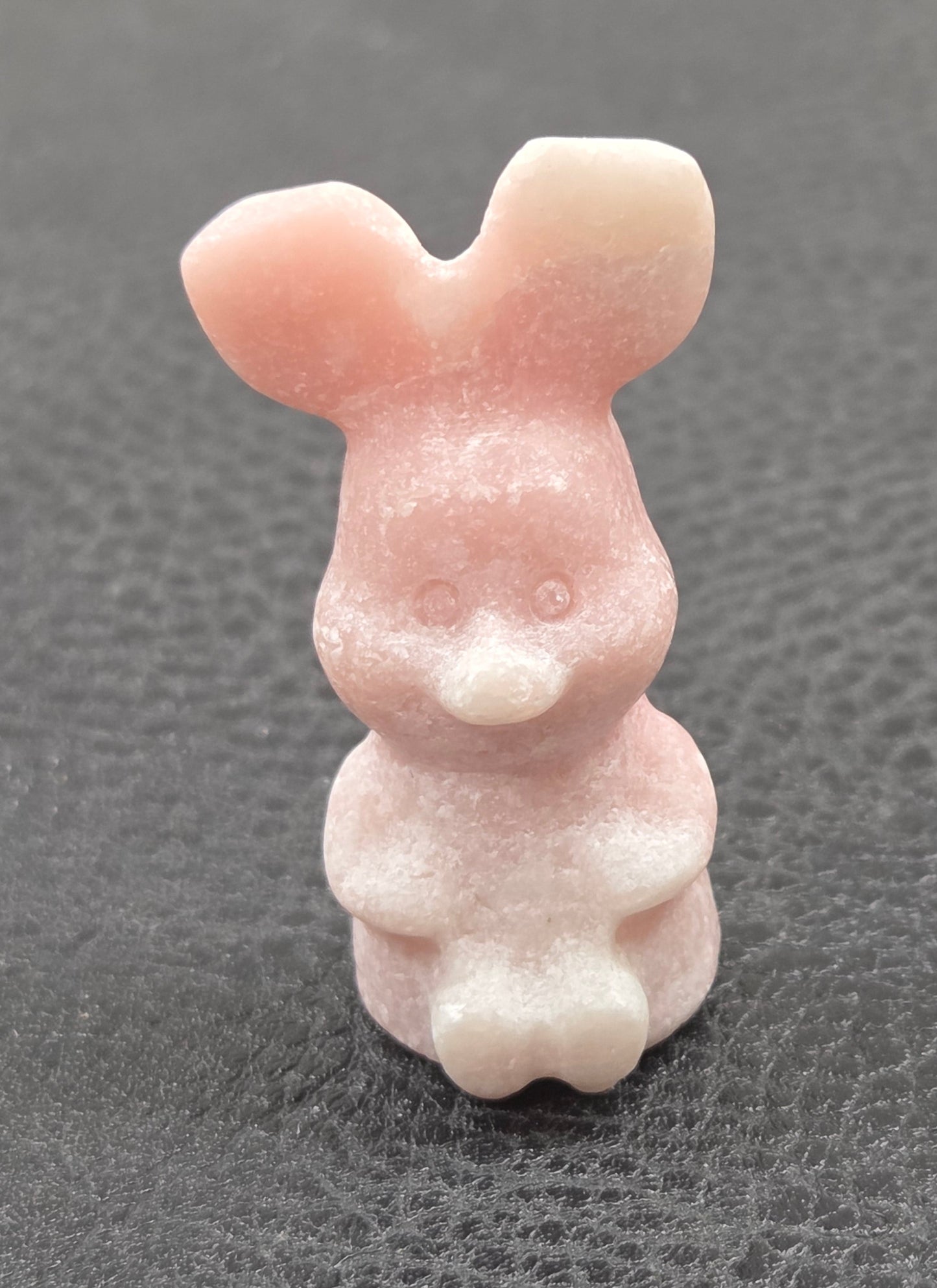 Pink Opal Piglet carving, from Winnie the pooh, on a dark background