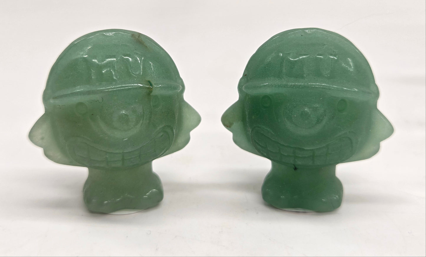Two Green Aventurine Mike Wazowski characters, for Monsters Inc., with helmets on a white background