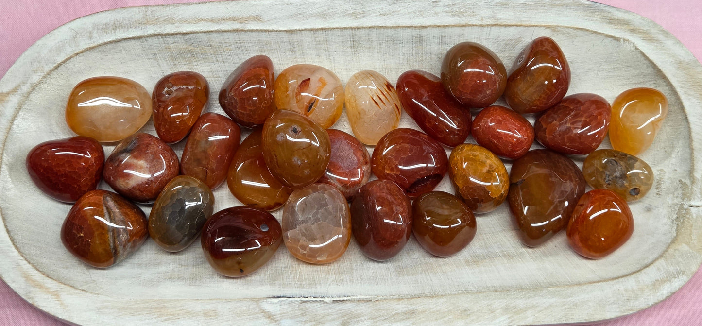 Assorted polished gemstones, called Fire Agate, in varying colors of red, orange, clear and yellow