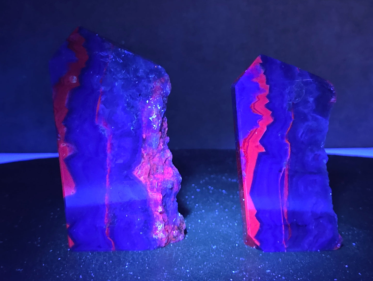 Fluorite towers under UV light on a dark surface