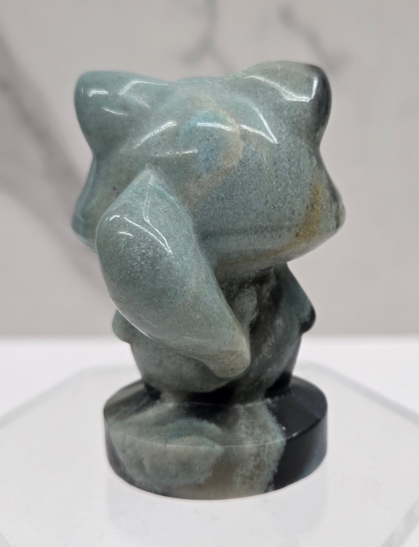 Decorative raccoon carving with blue and black coloring on a white background