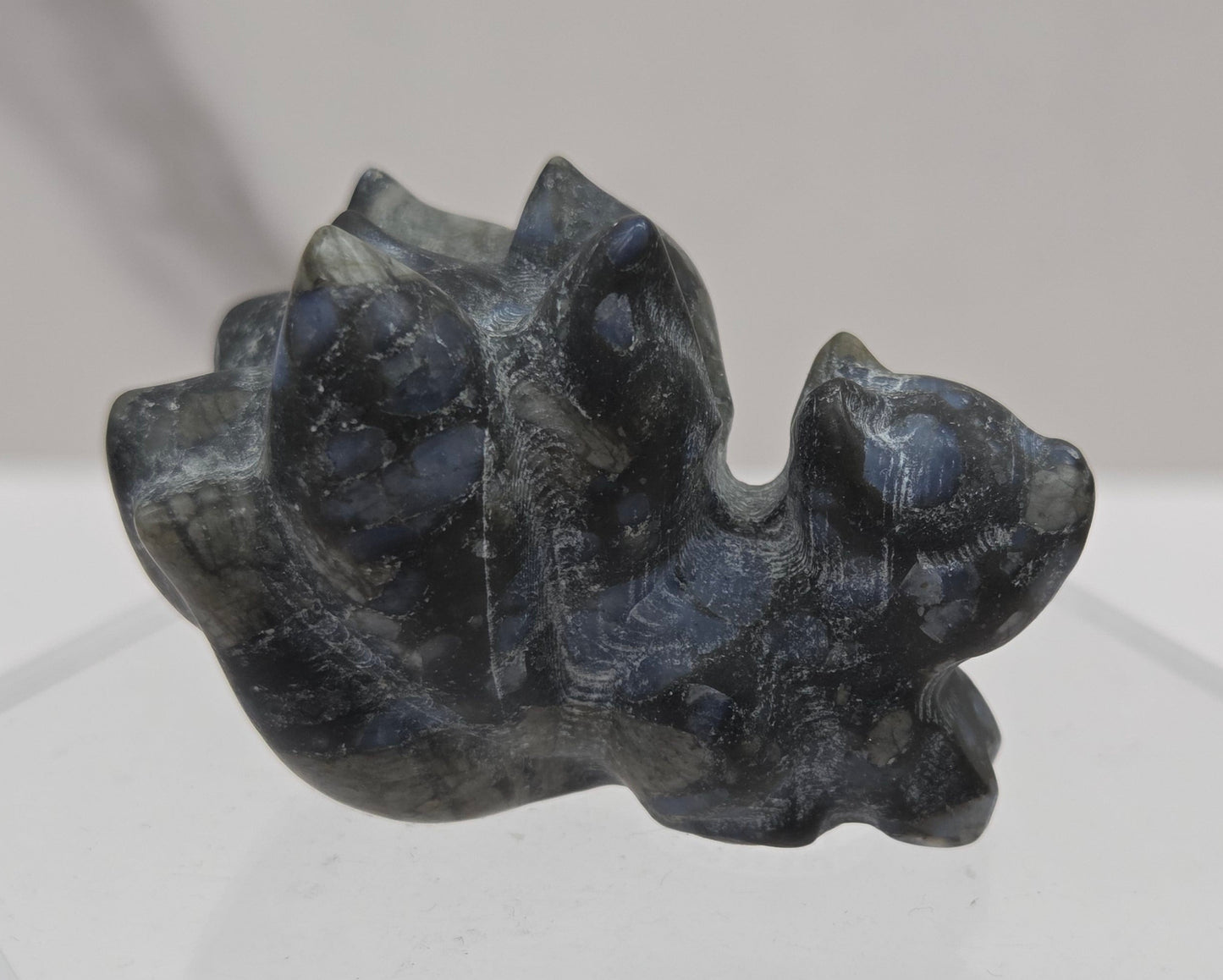 Carved stone 9 tail figurine with multiple colors on a white background