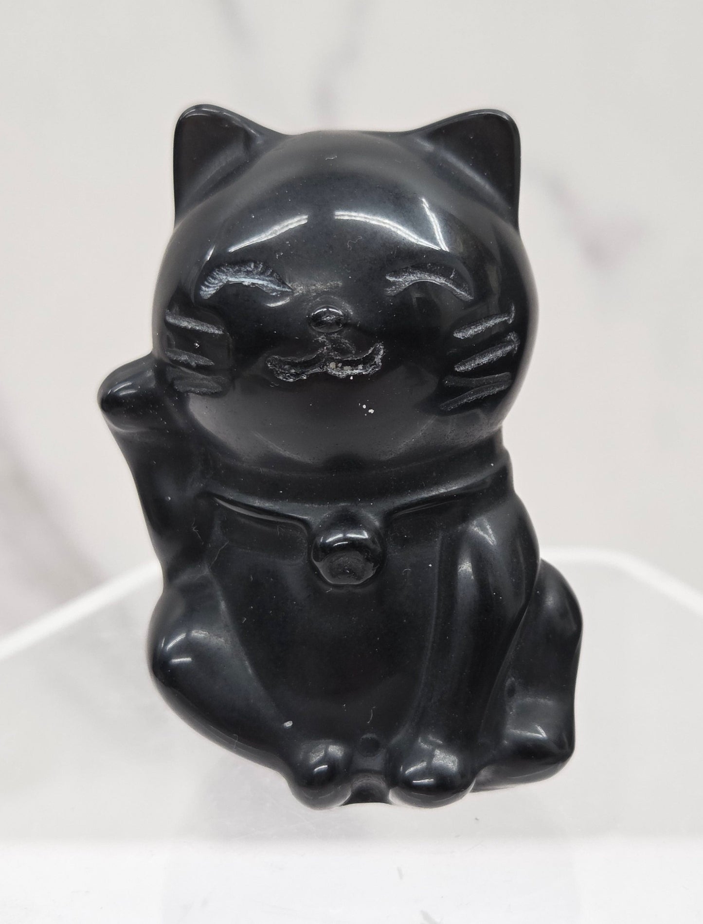 Black cat-shaped object on a white geometric background