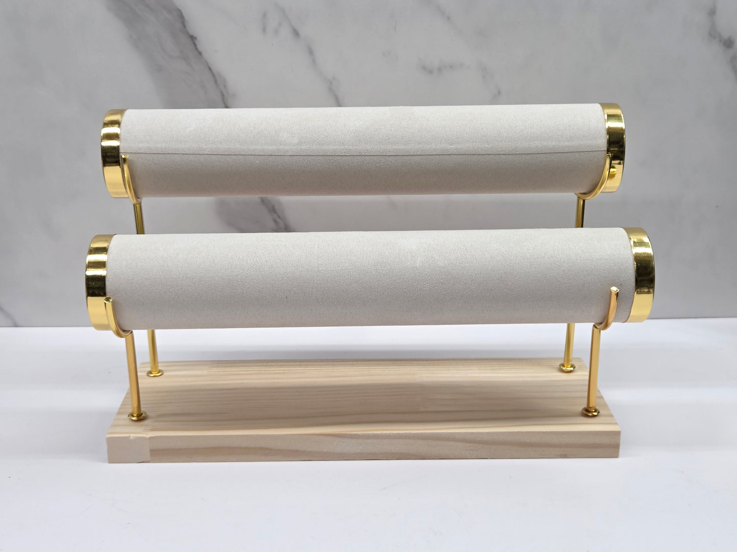 Two-tiered bracelet holder with gold accents on a marble background