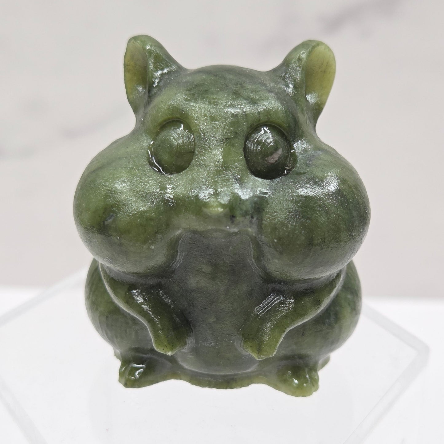 Green Jade carving of a chipmunk on an acrylic block against a white background