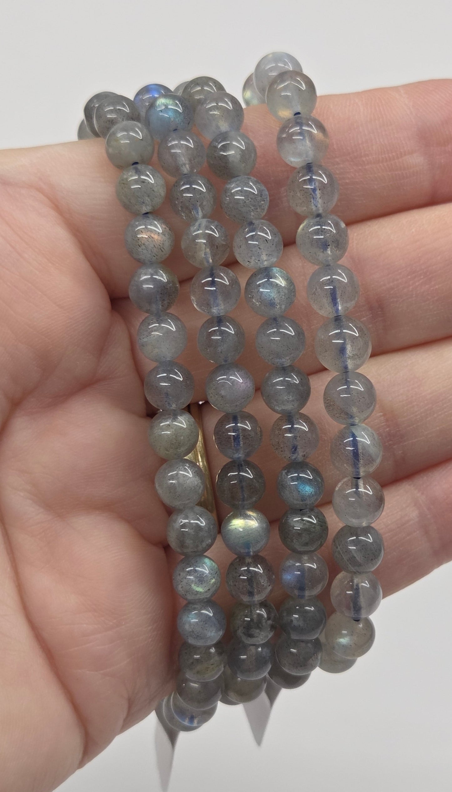 Beaded bracelets on a hand against a plain background