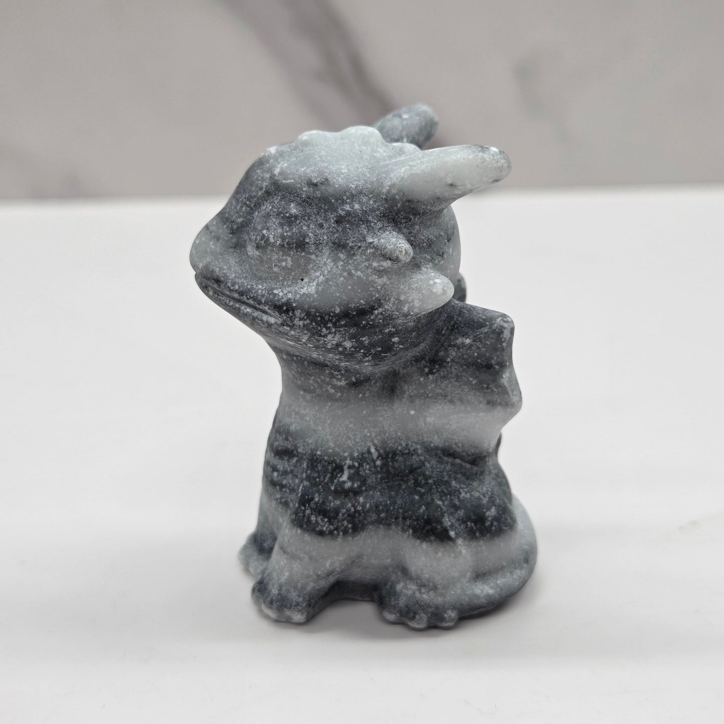 Grey striped dragon carving on a white background