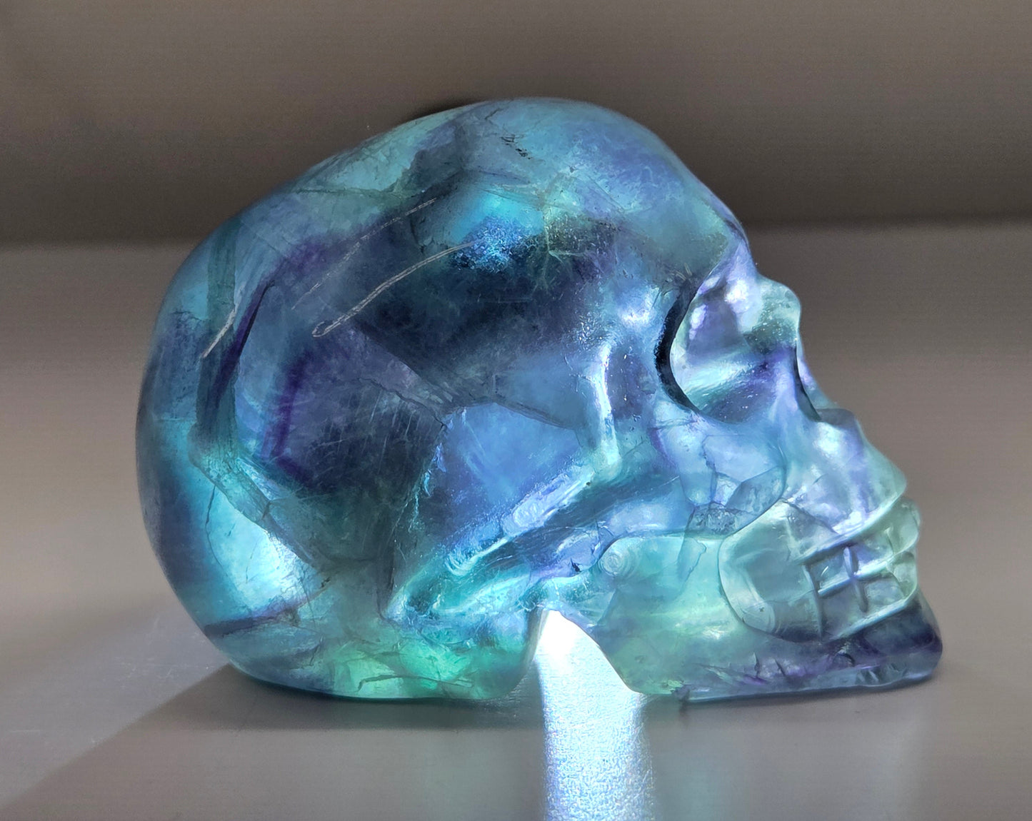 Backlit Fluorite skull carving on a white background