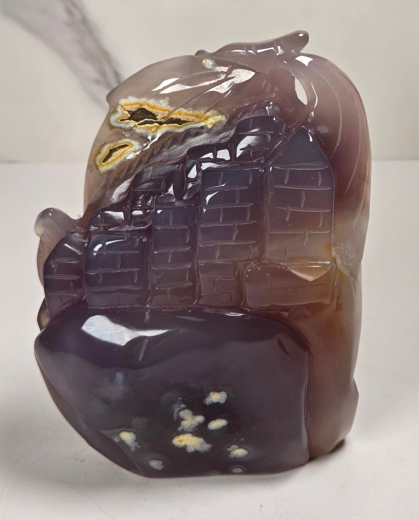druzy agate carved dragon with a crystal pocket against a marbled background