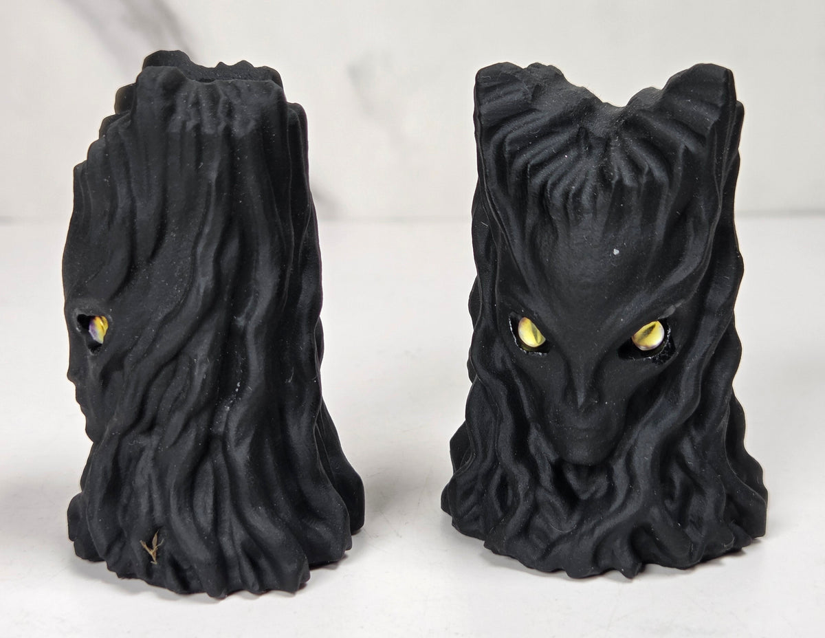 faceless lady reaper carving made of a off-white mineral against a marbled white background