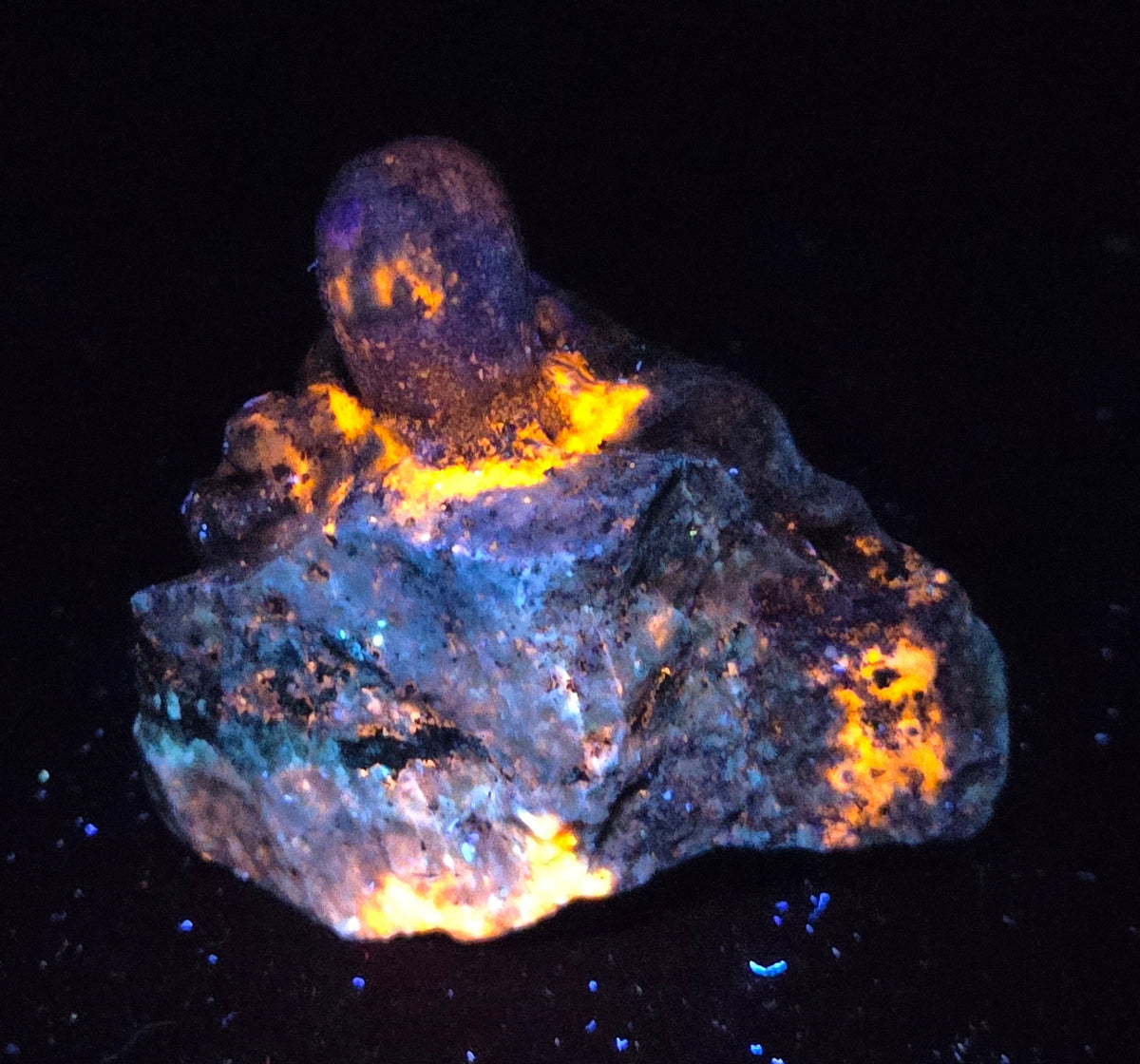 Blue crystal octopus carving with glowing orange under UV light against a marbled background