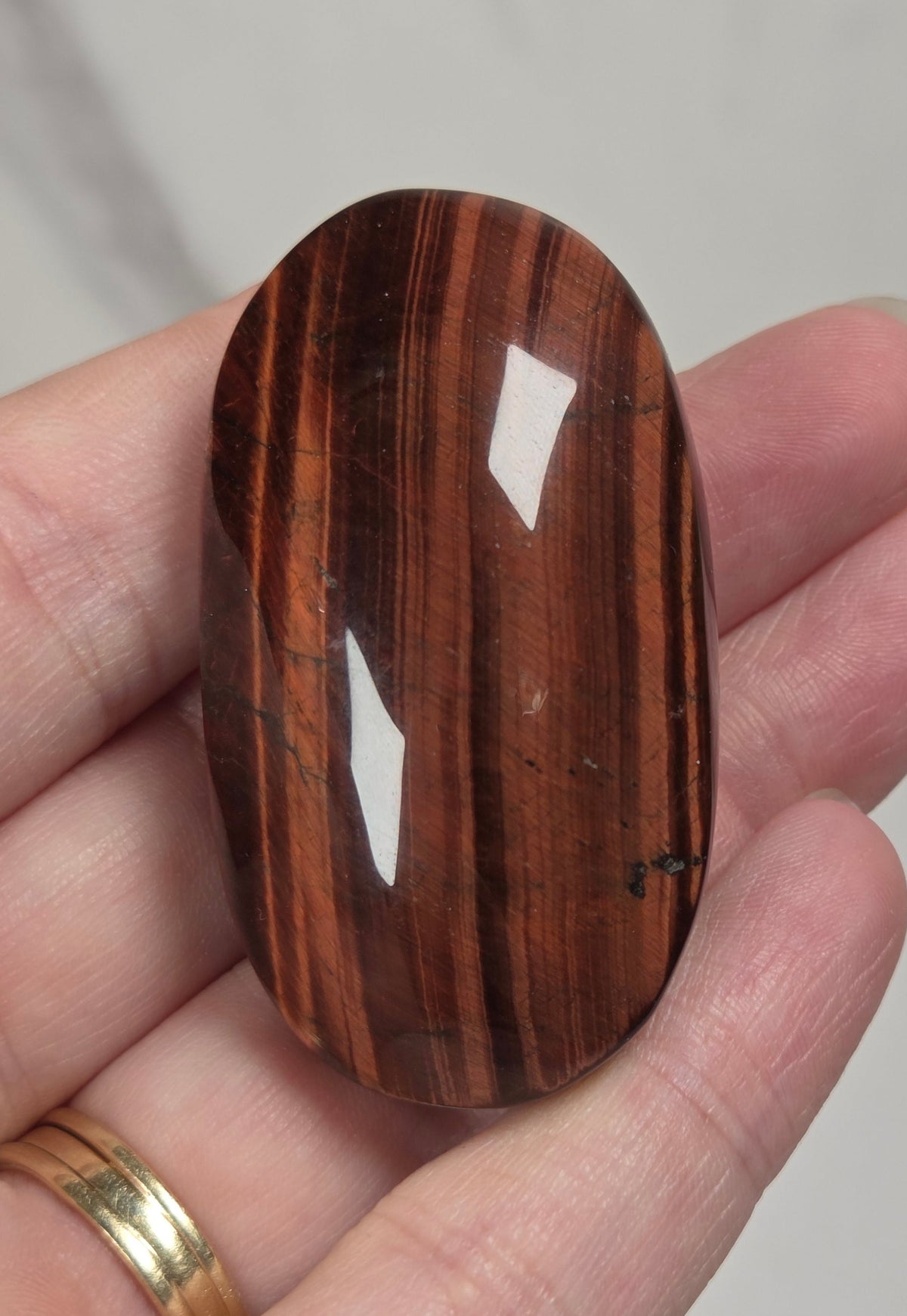 collection of red tigers eye crystal carvings with bands against a white background