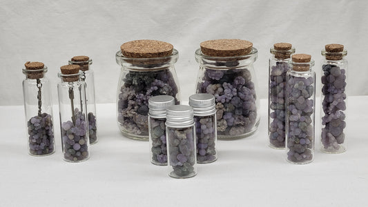 Collection of bottles filled with Grape Agate crystals, each bottle with a cork top