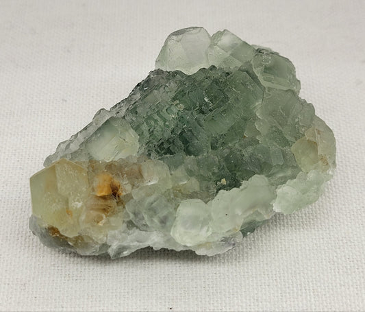A polished green fluorite crystal with natural variations in color and shape.