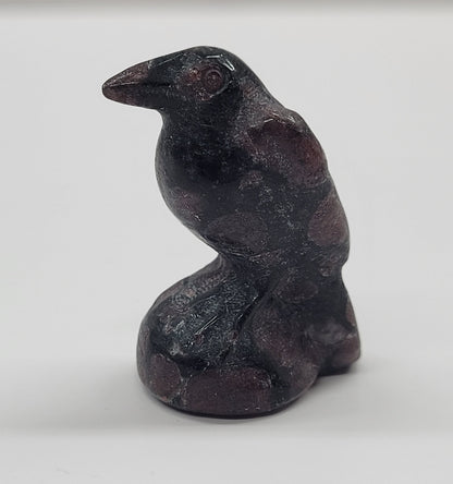 A small carving of a raven made from Garnet, approximately 1.5 inches tall.