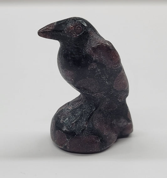 A small carving of a raven made from Garnet, approximately 1.5 inches tall.