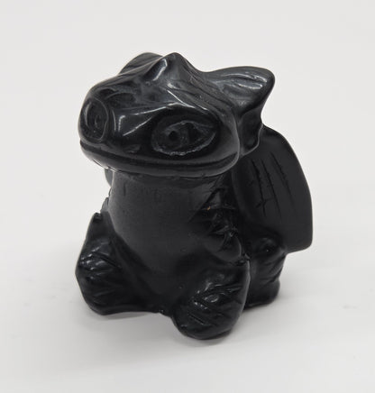 Obsidian carving of Toothless on a white background