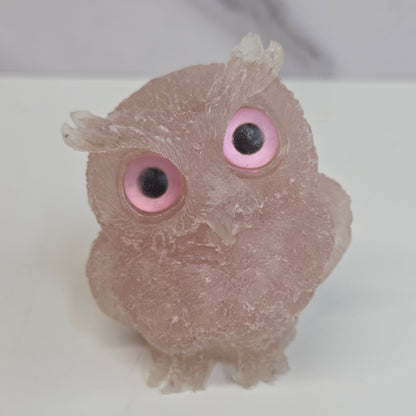 A resin owl figurines with various colorful crystal chips embedded within, displayed on a white background.