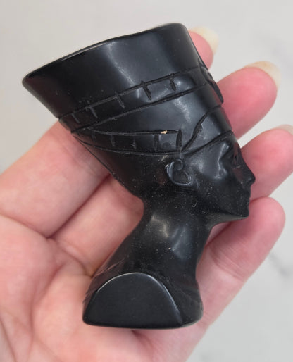 black Obsidian Nefertiti bust with decorative patterns on a white surface.