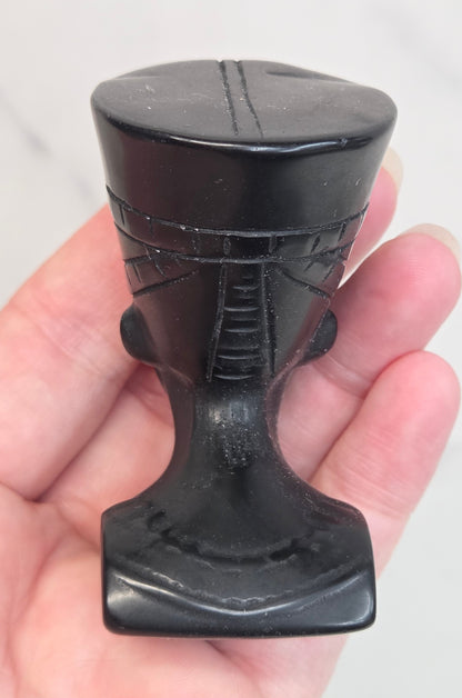 black Obsidian Nefertiti bust with decorative patterns on a white surface.