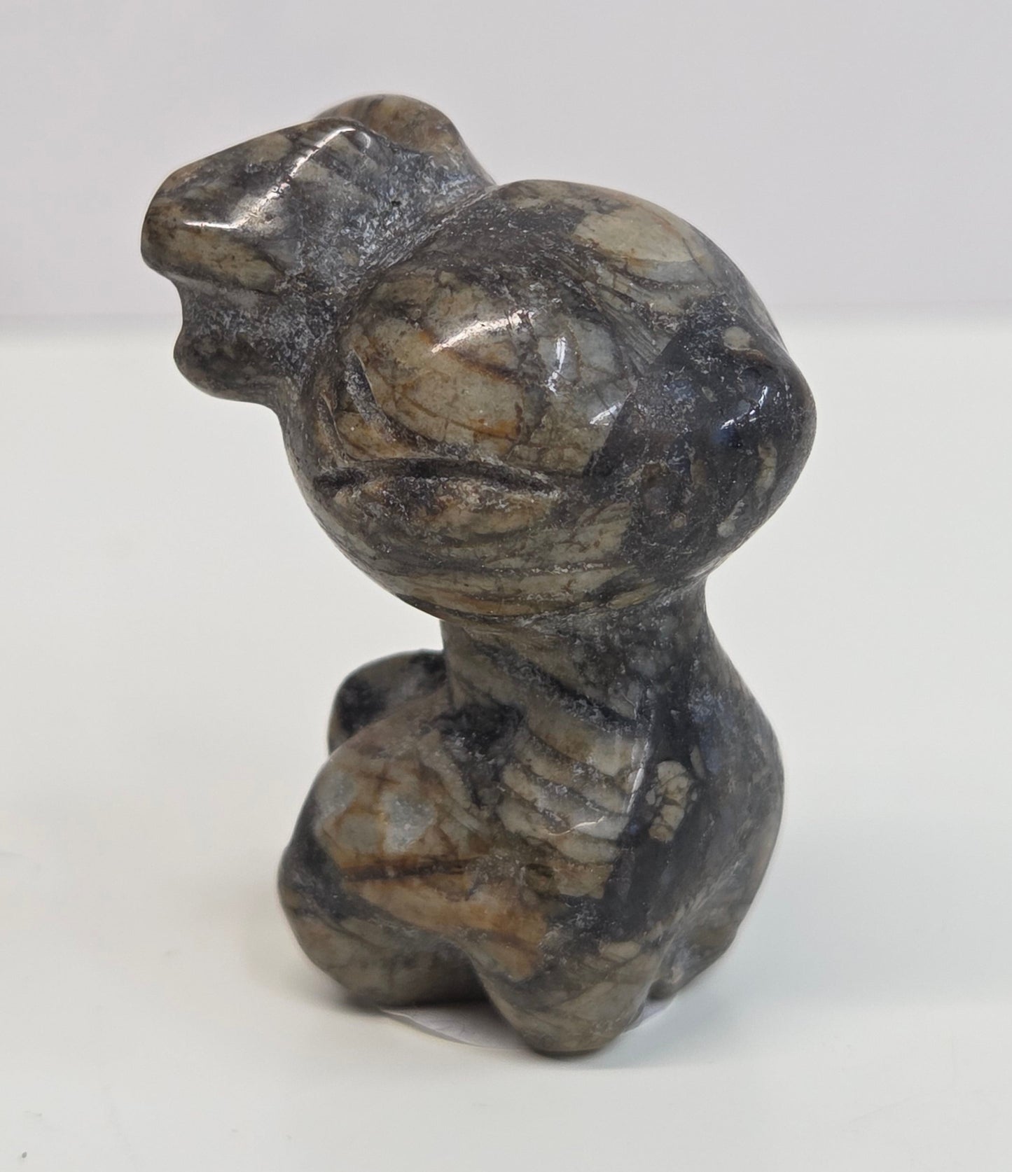 small reindeer carving with tan and black coloring on a white background