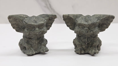 Set of Pyrite Gremlin sculptures on a clear stand with a neutral background