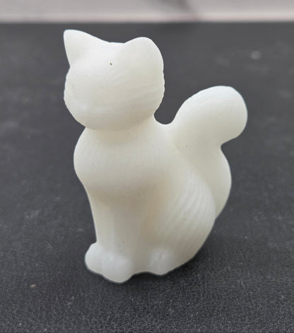 White cat-shaped object on a black surface