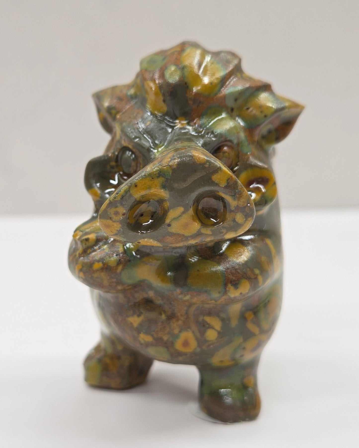 crystal Pumbaa figurine with various colors and patterns on a white surface with a neutral background