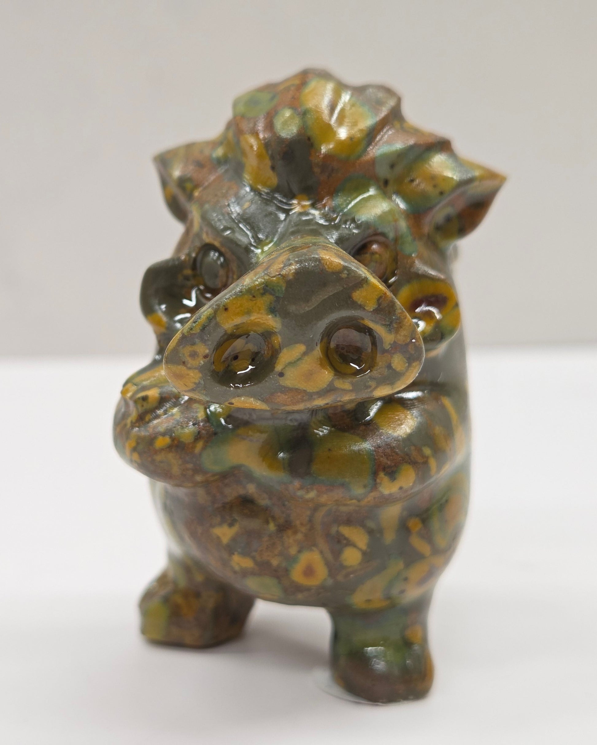crystal Pumbaa figurine with various colors and patterns on a white surface with a neutral background