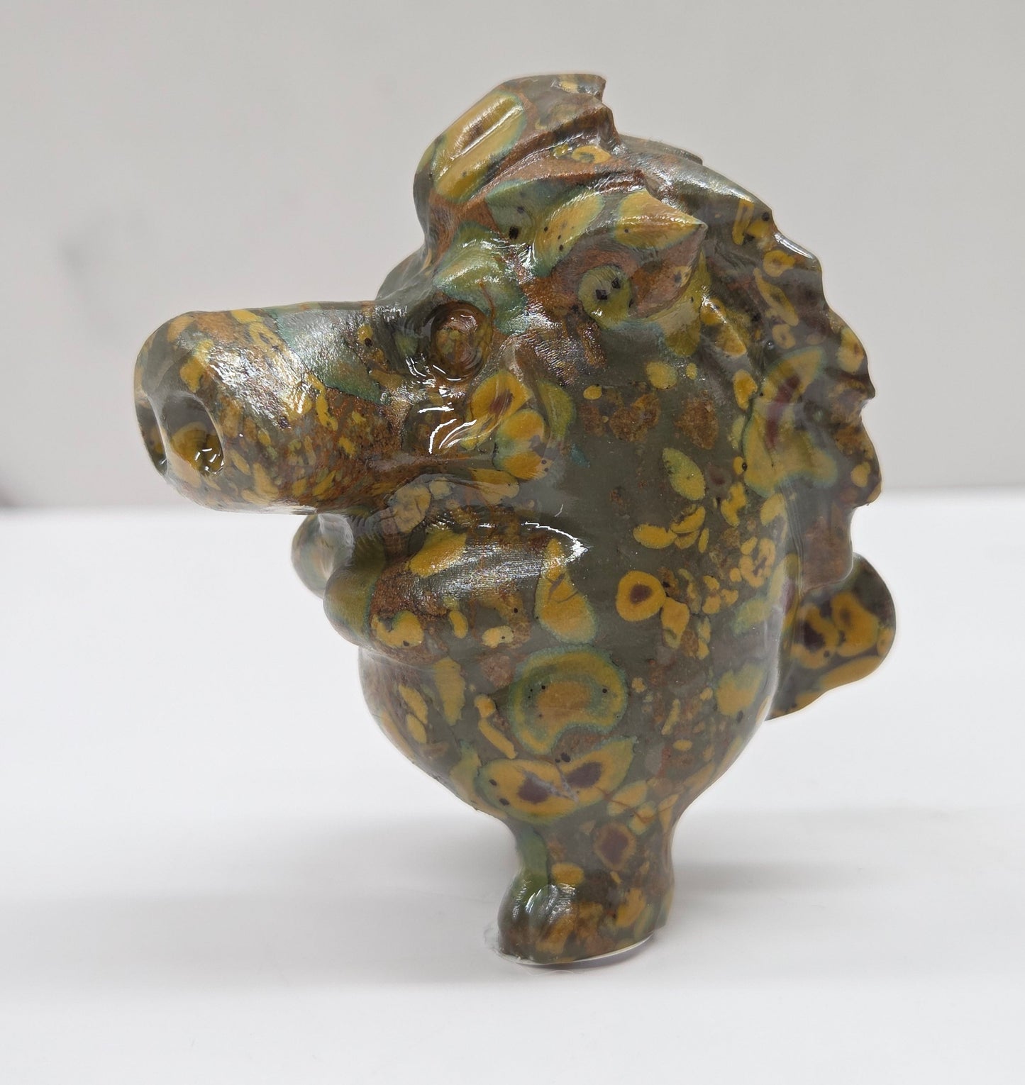 crystal Pumbaa figurine with various colors and patterns on a white surface with a neutral background