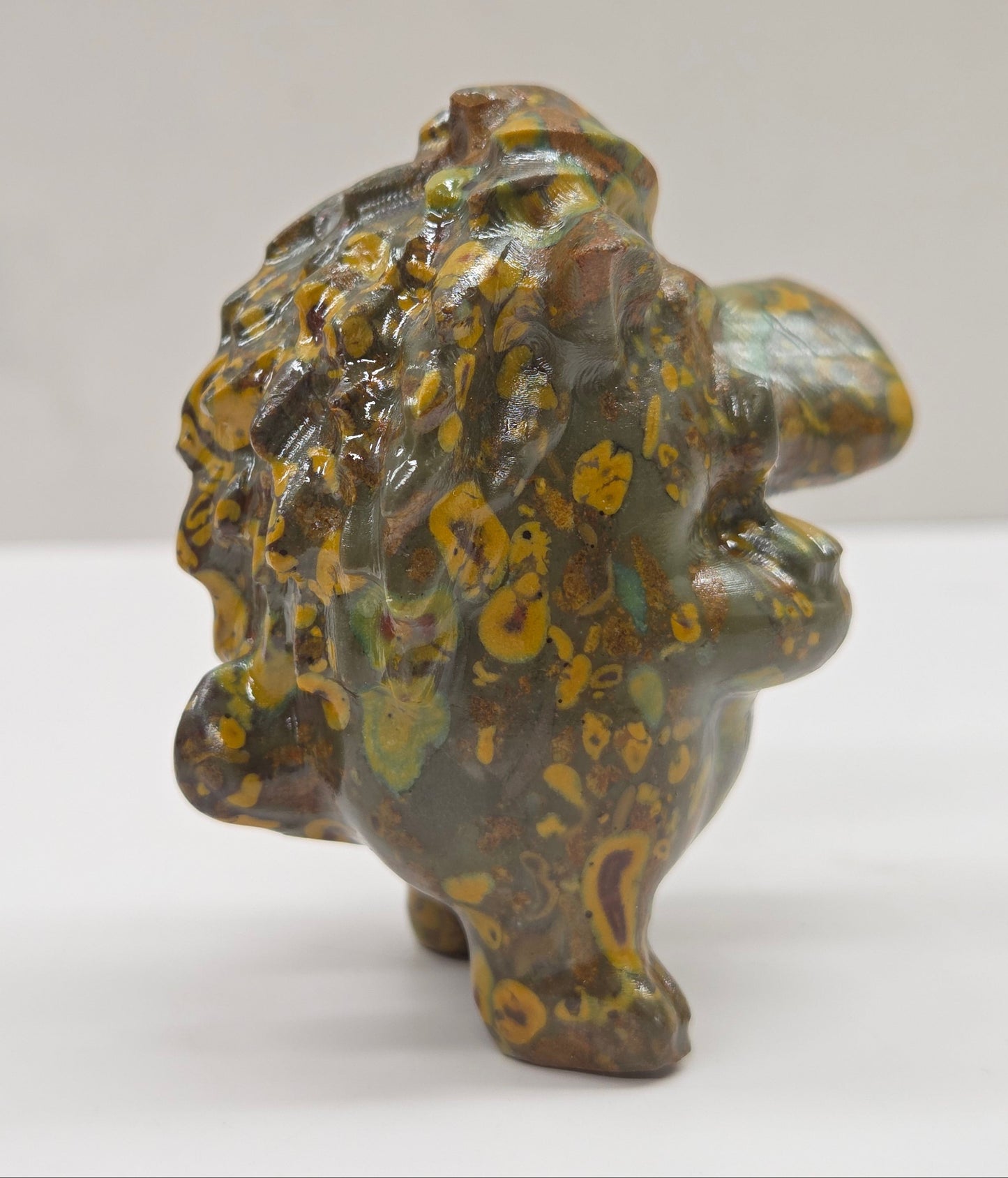 crystal Pumbaa figurine with various colors and patterns on a white surface with a neutral background