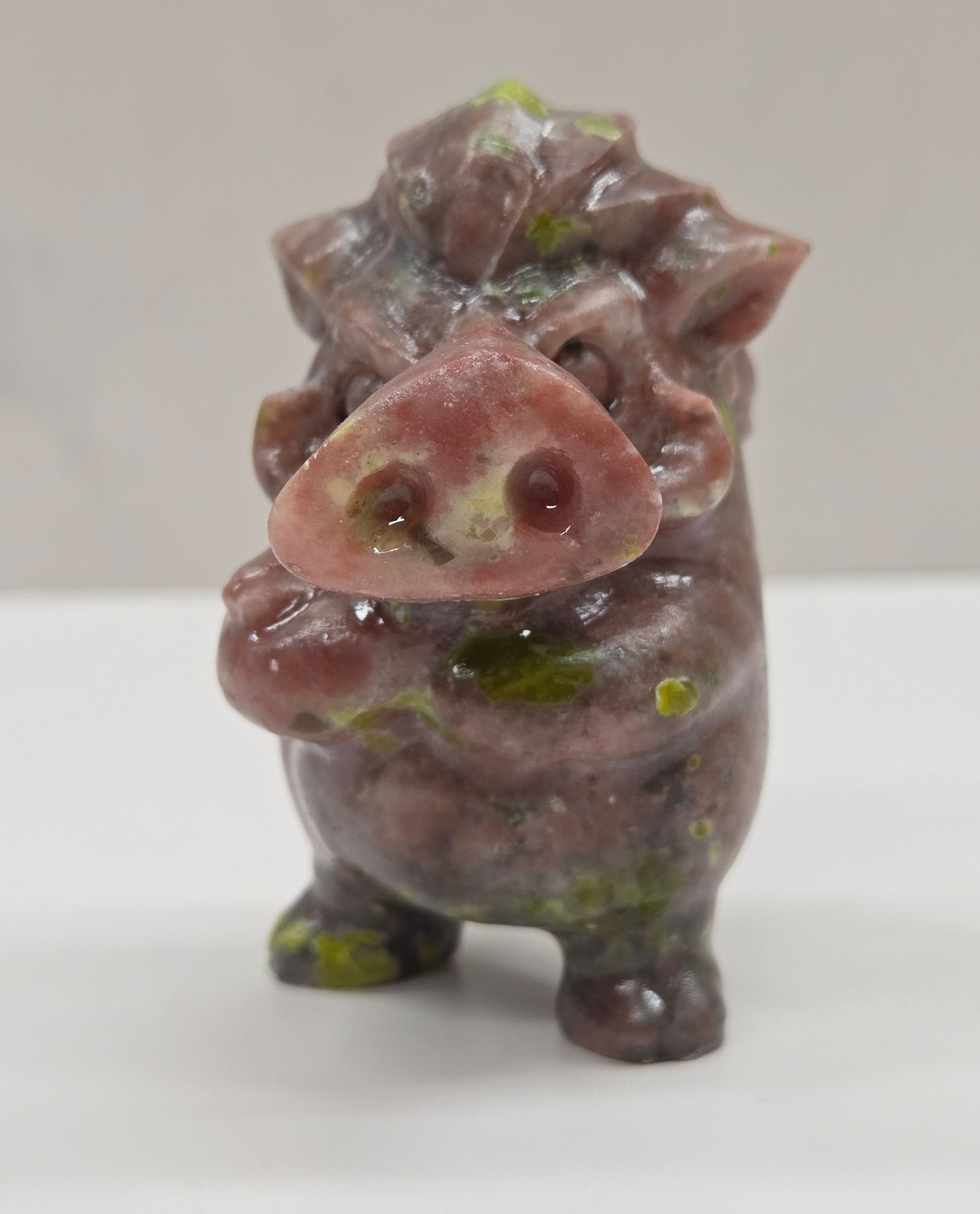 crystal Pumbaa figurine with various colors and patterns on a white surface with a neutral background