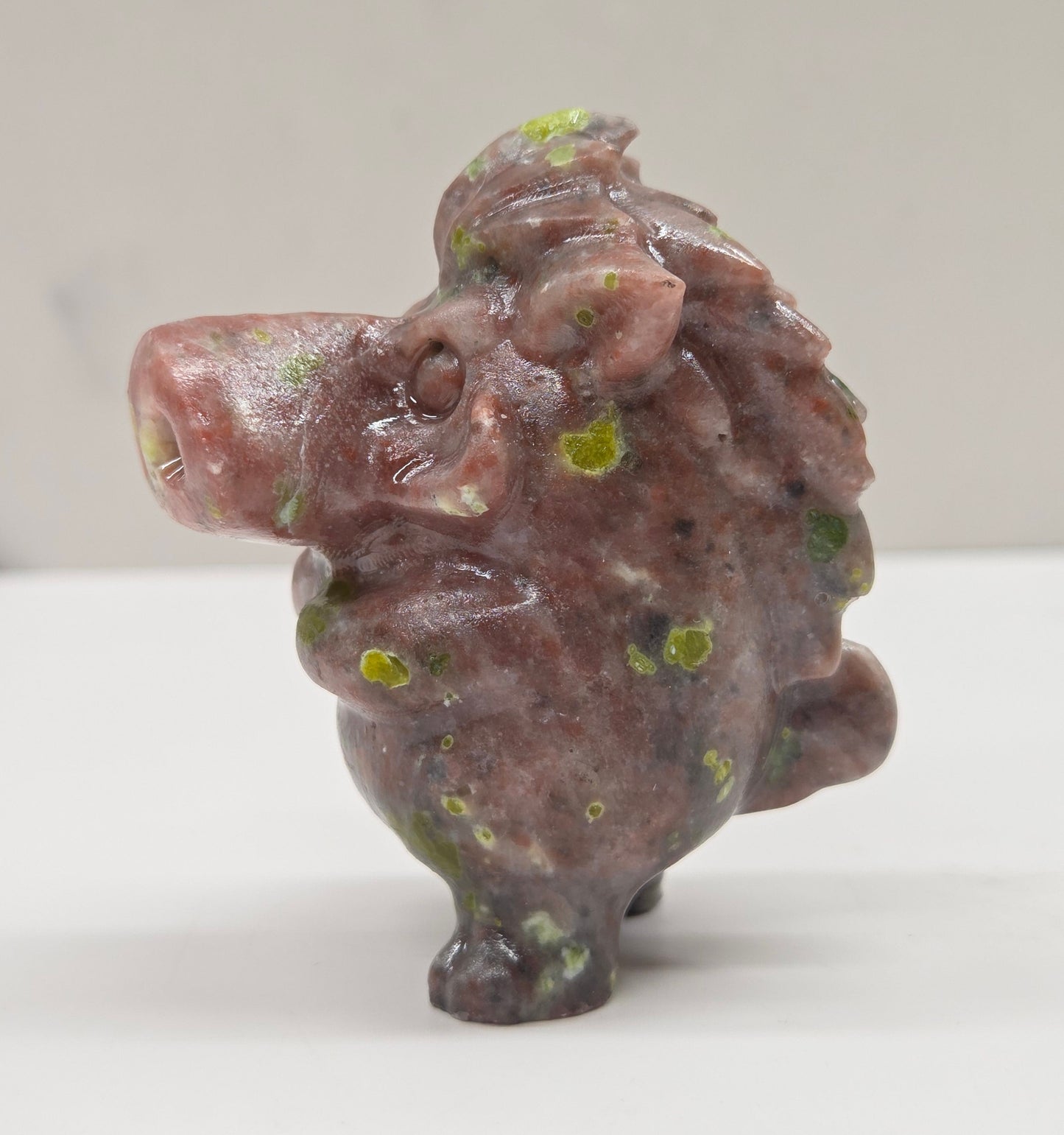 crystal Pumbaa figurine with various colors and patterns on a white surface with a neutral background