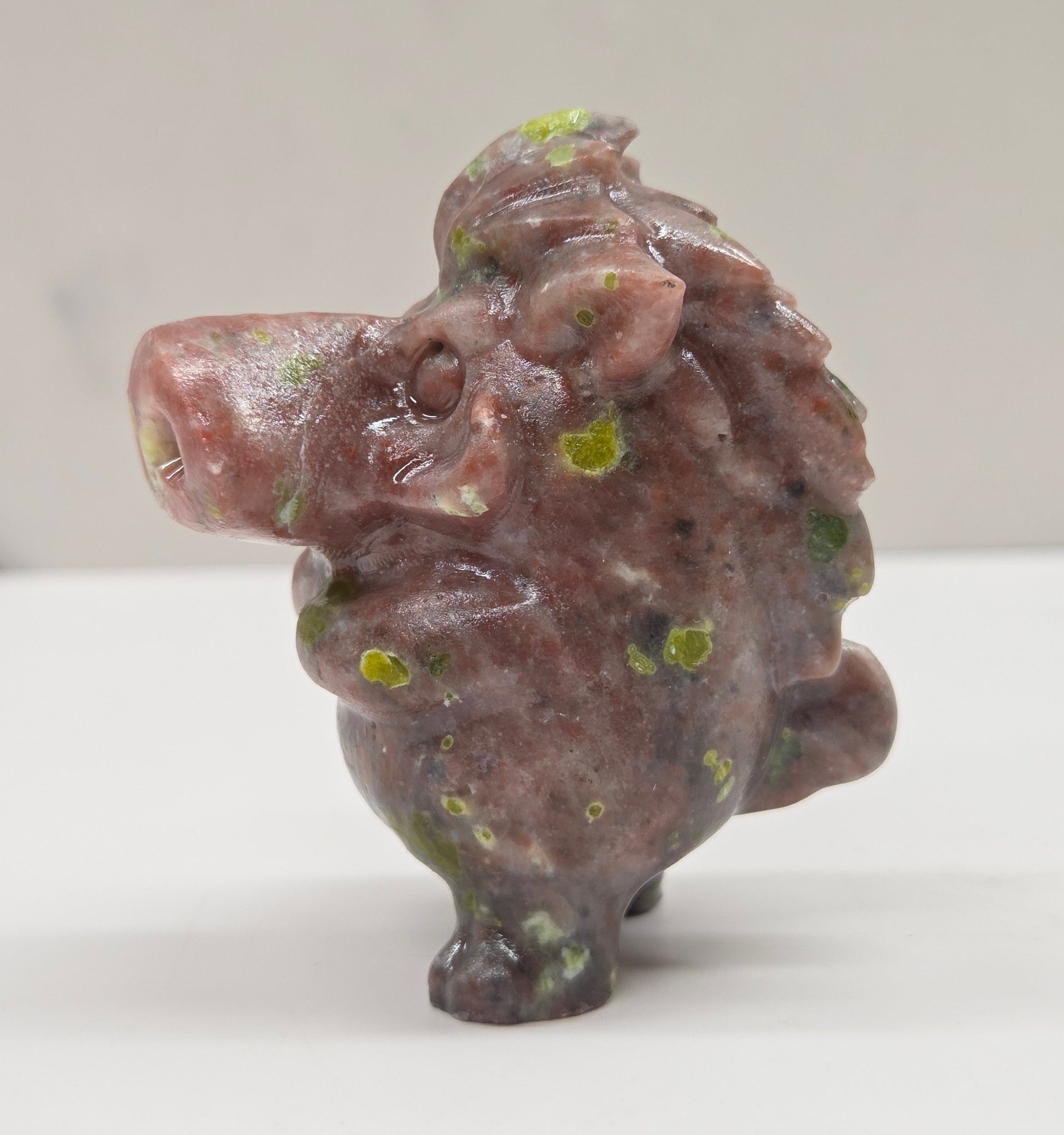 crystal Pumbaa figurine with various colors and patterns on a white surface with a neutral background