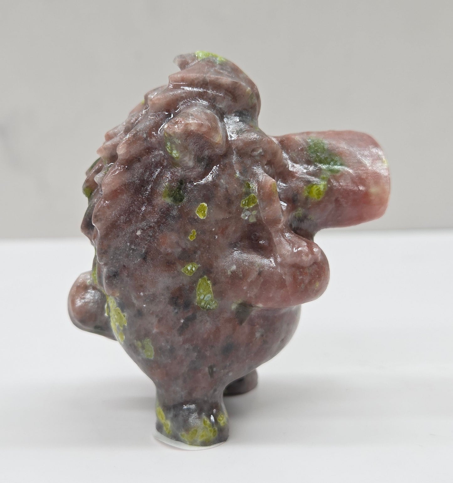 crystal Pumbaa figurine with various colors and patterns on a white surface with a neutral background