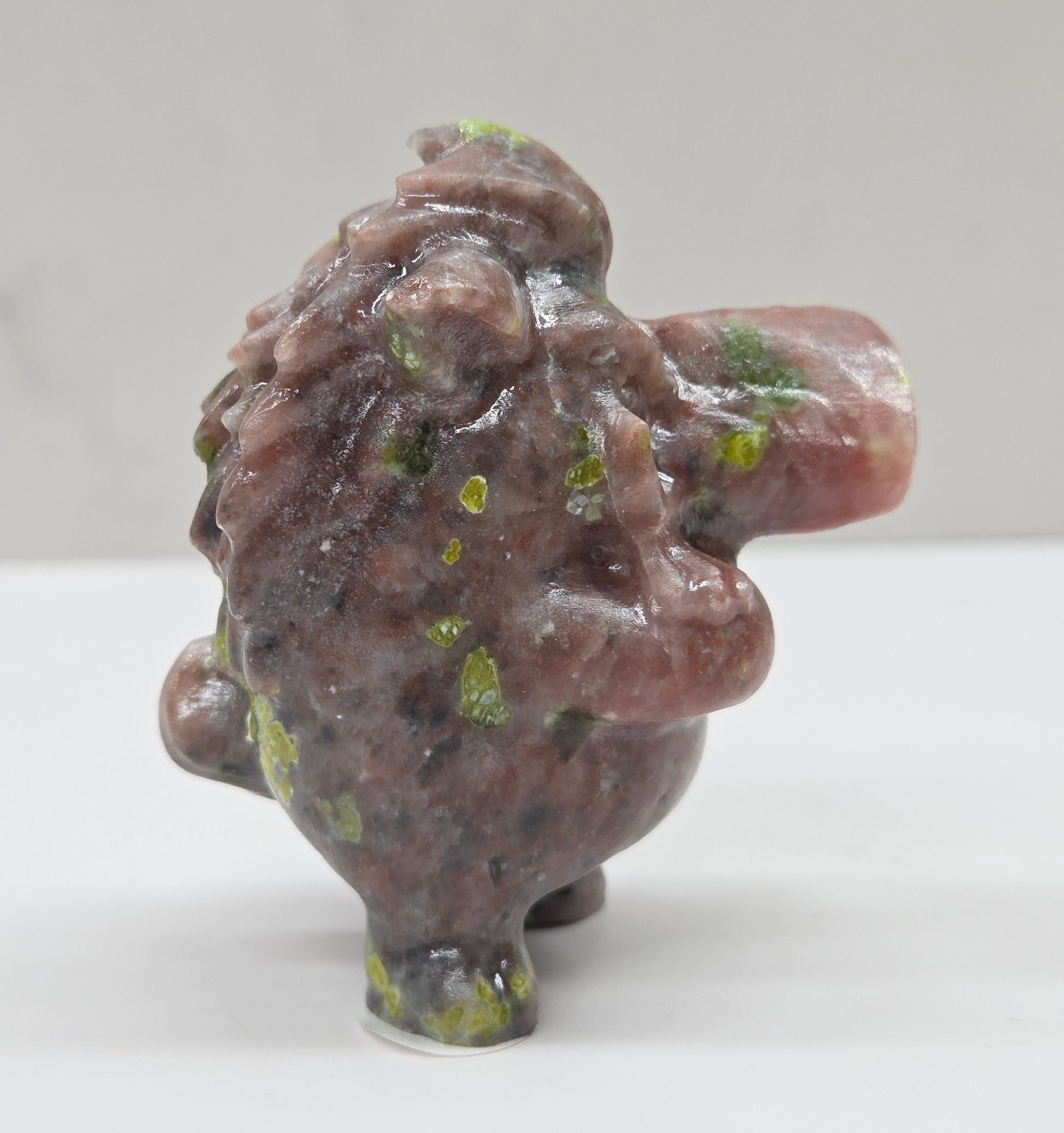 crystal Pumbaa figurine with various colors and patterns on a white surface with a neutral background