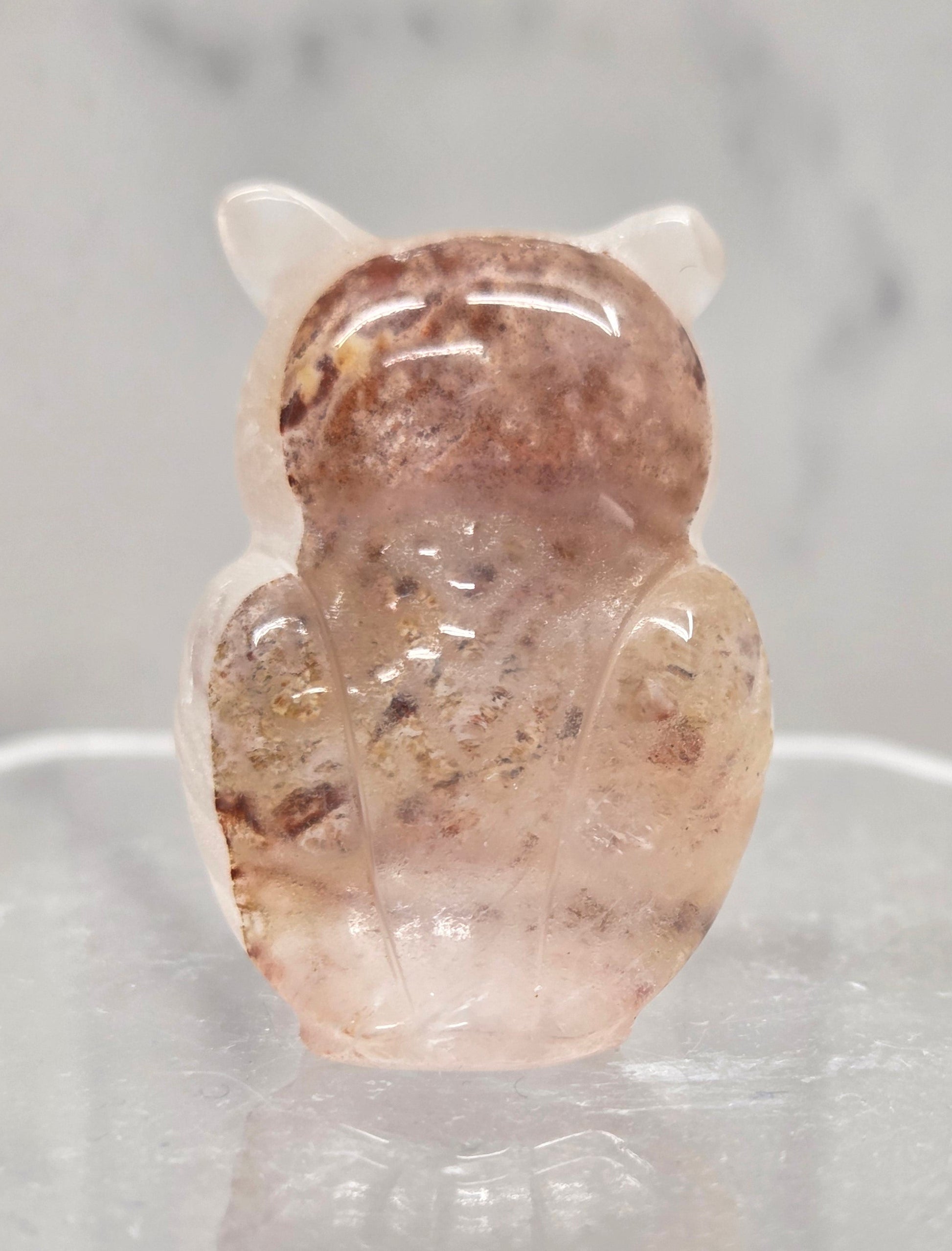 Fire Quartz grumpy owl carving on a white background