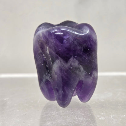 Dream Amethyst tooth on a white background