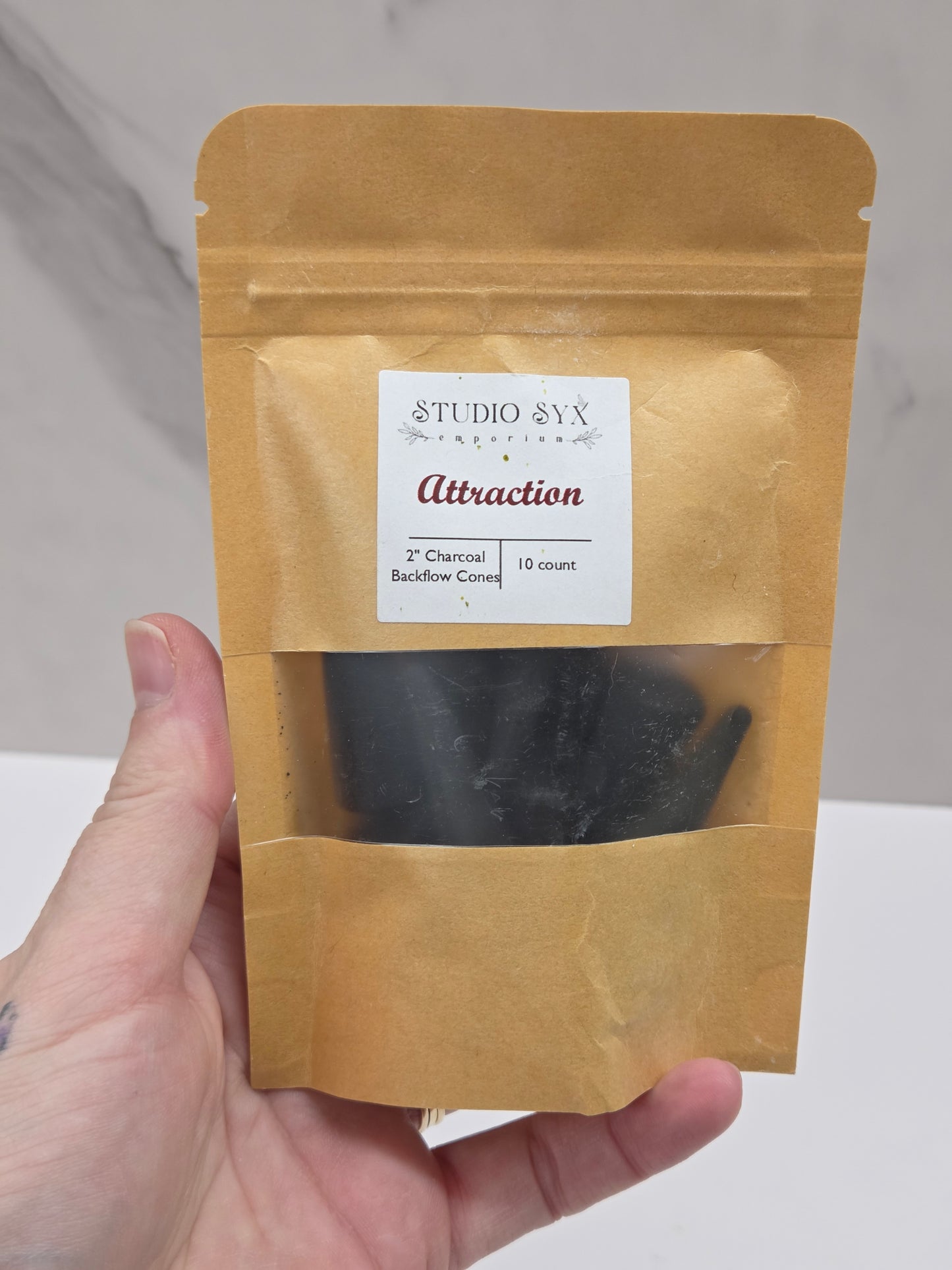 Packaging of 'Attraction' incense cones with a label showing the brand information.