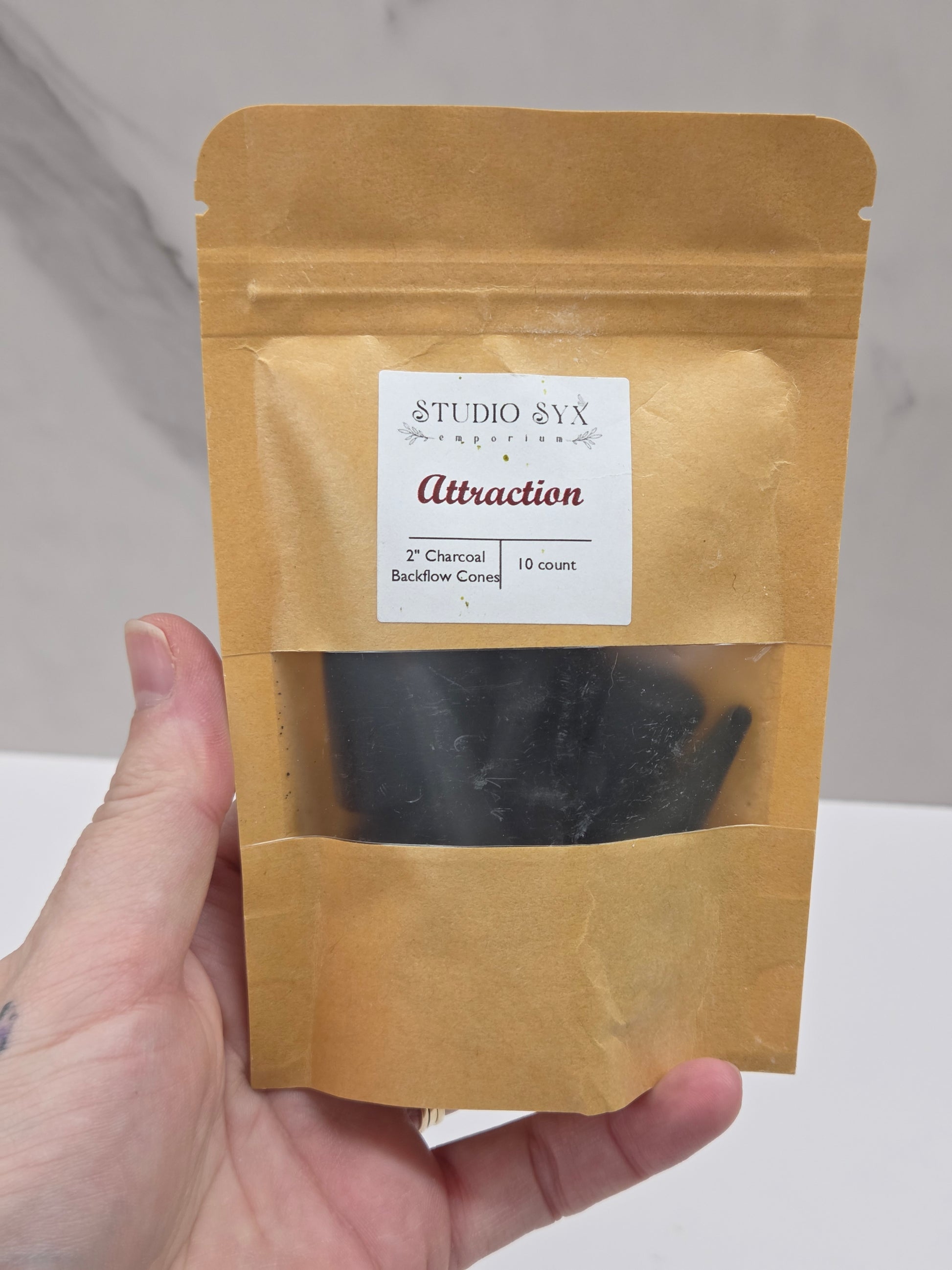 Packaging of 'Attraction' incense cones with a label showing the brand information.