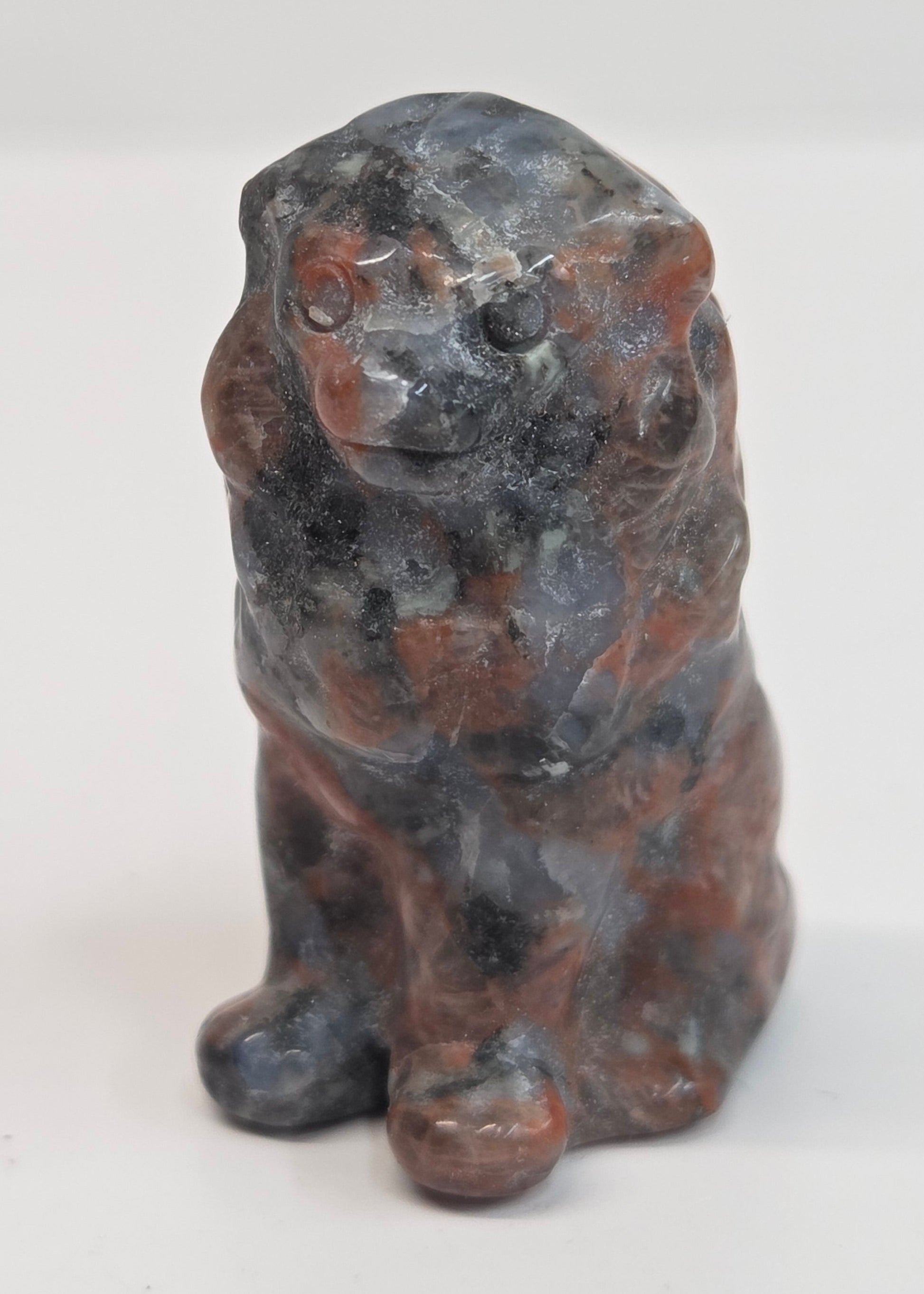 Red Jasper crystal lion carving on a white background