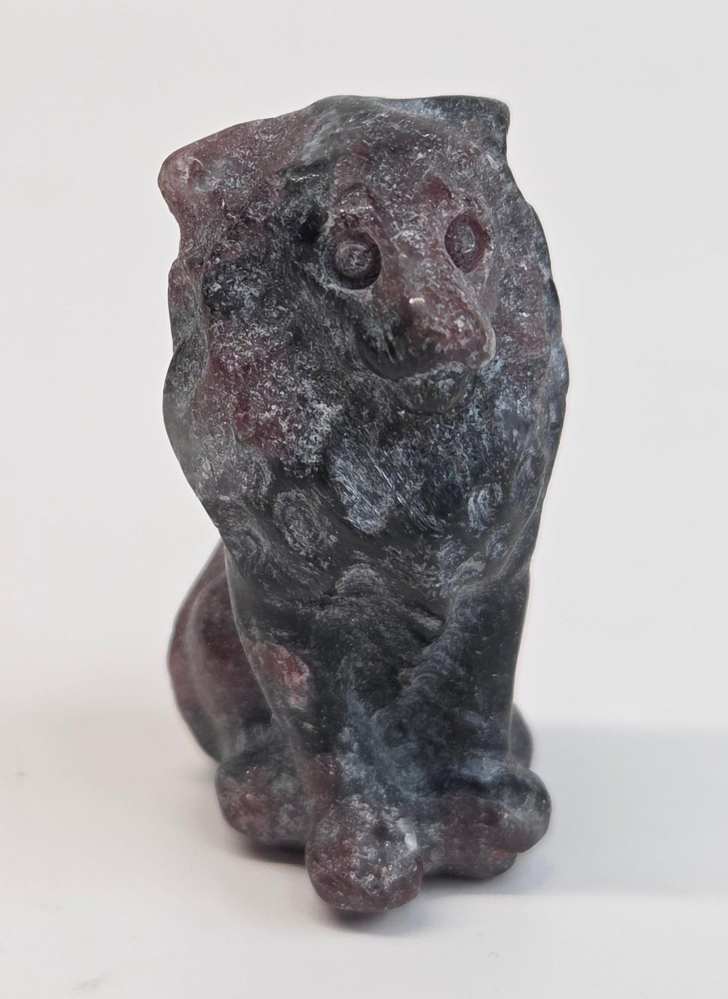 Garnet crystal lion carving on a white background