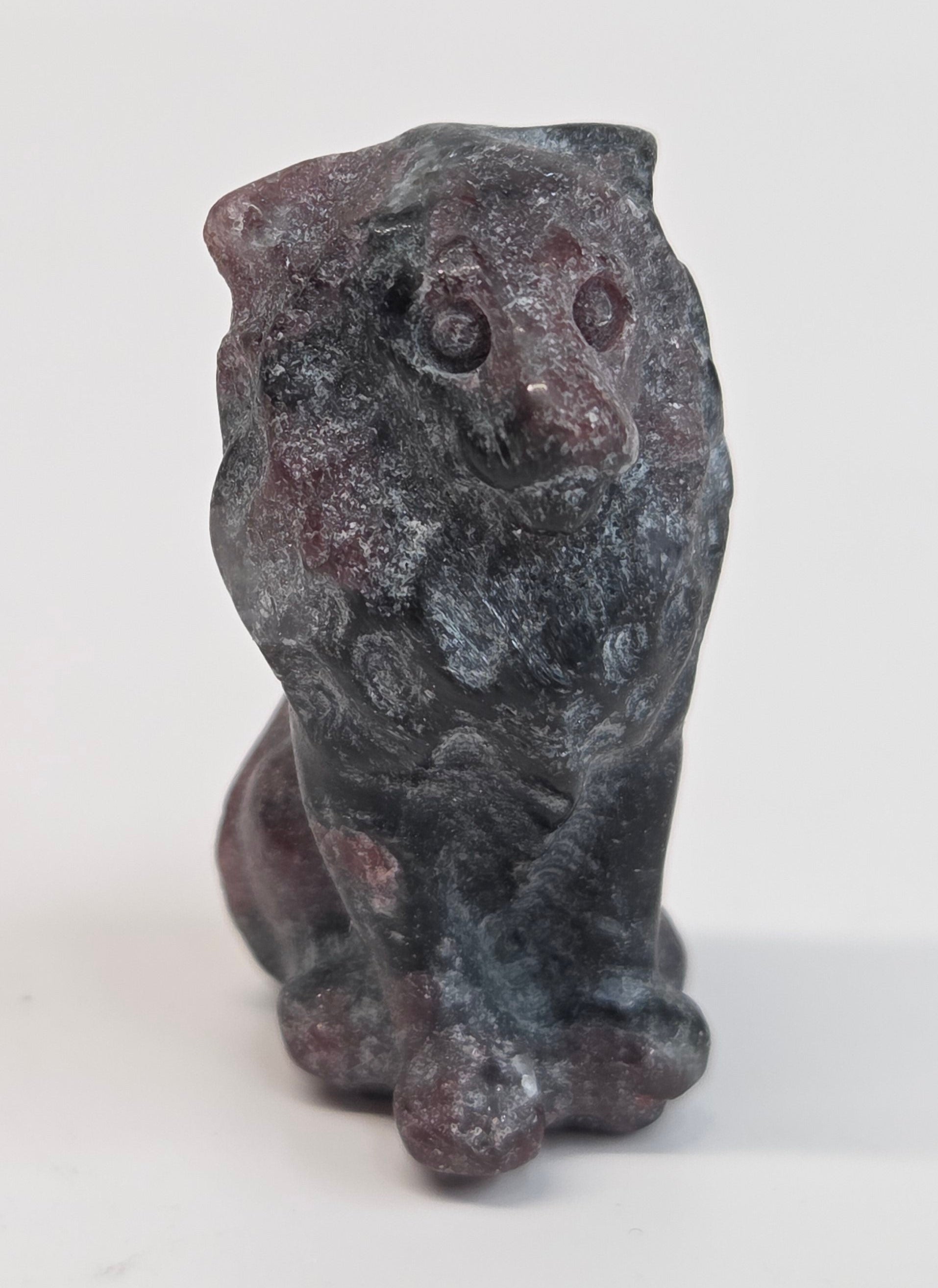 Garnet crystal lion carving on a white background