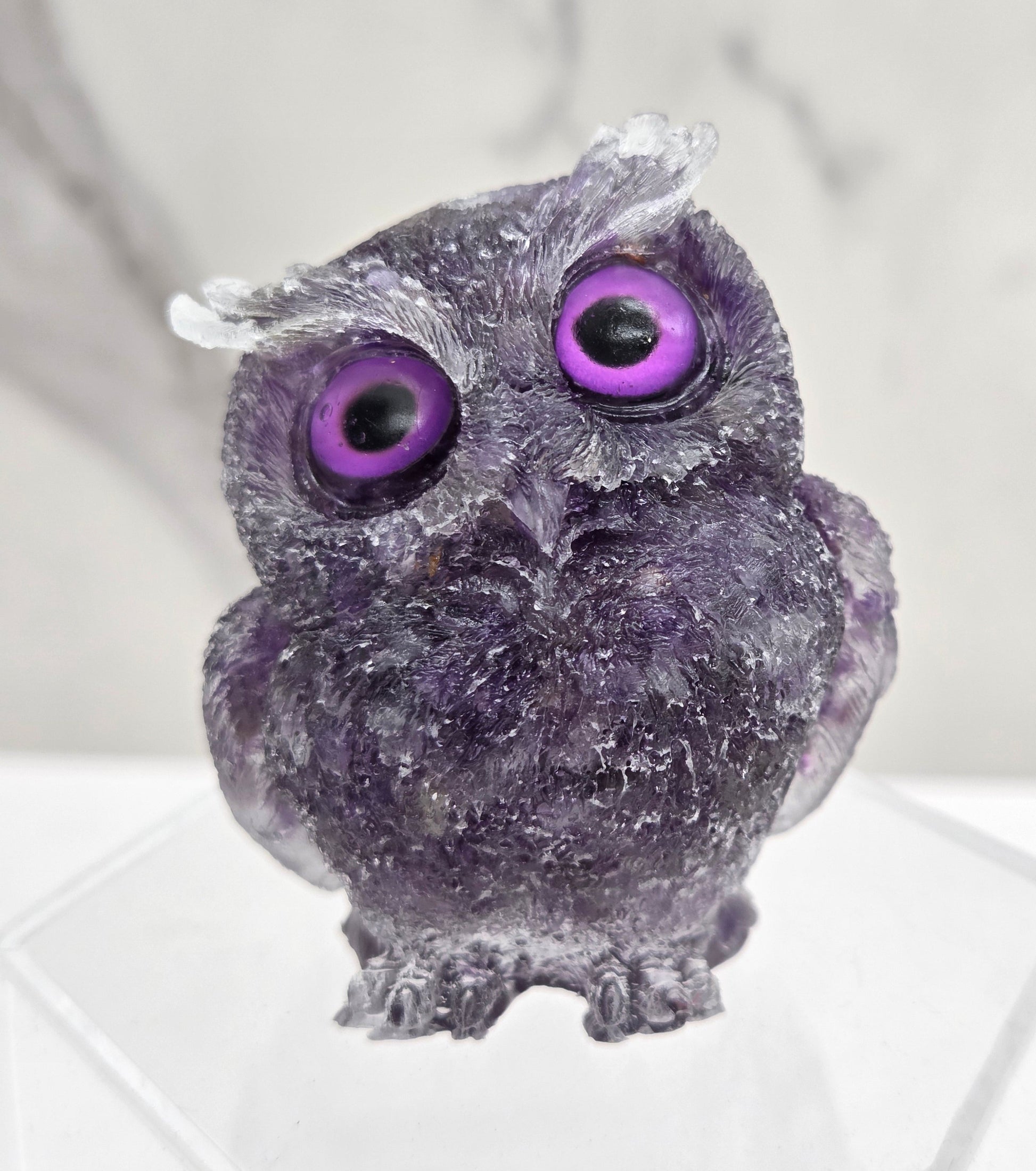 A resin owl figurines with various colorful crystal chips embedded within, displayed on a white background.