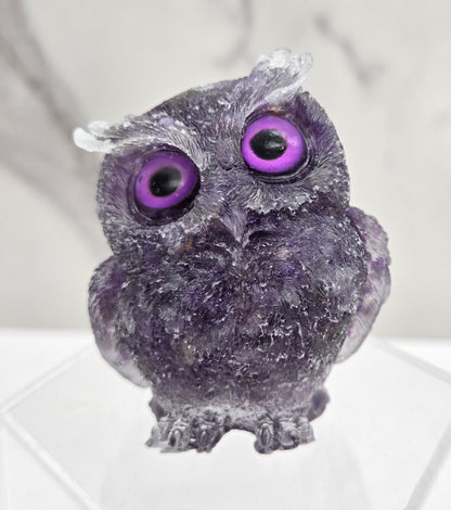 A resin owl figurines with various colorful crystal chips embedded within, displayed on a white background.