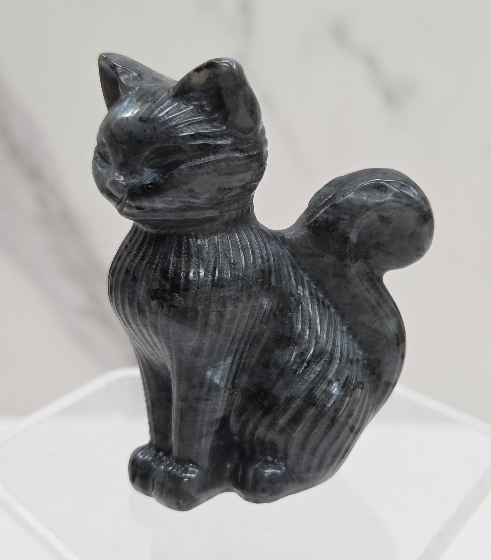 Black stone carving of a cat figure on a white background